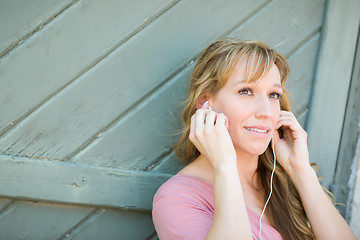 Image showing Outdoor Portrait of Young Adult Brown Eyed Woman Listening To Mu