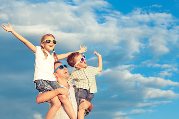 Image showing Father and children playing in the park  at the day time.