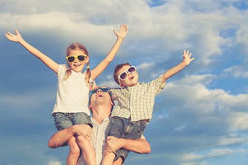 Image showing Father and children playing in the park  at the day time.