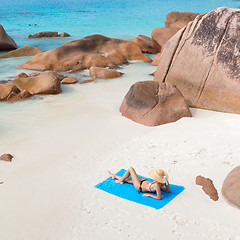 Image showing Woman sunbathing at Anse Lazio picture perfect beach on Praslin Island, Seychelles.