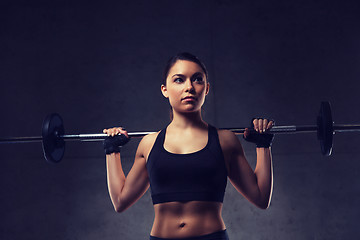 Image showing young woman flexing muscles with barbell in gym