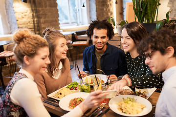 Image showing friends with smartphone eating at restaurant