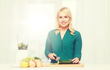 Image showing smiling woman with blender cooking food at home