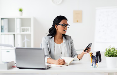 Image showing businesswoman with smartphone and laptop at office