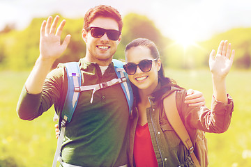 Image showing happy couple with backpacks hiking outdoors