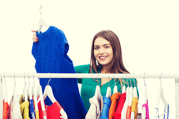 Image showing happy woman choosing clothes at home wardrobe