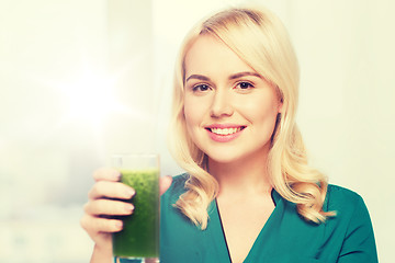Image showing smiling woman drinking juice or smoothie at home