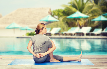 Image showing woman making yoga in twist pose on mat