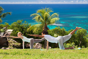 Image showing happy couple making yoga exercises outdoors