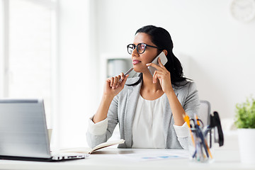 Image showing businesswoman calling on smartphone at office