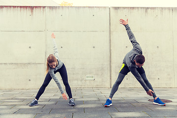 Image showing close up of couple stretching on city street