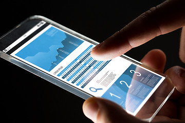 Image showing close up of hand with business chart on smartphone