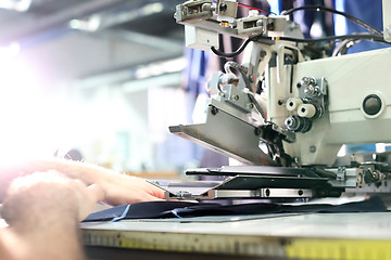 Image showing Overlock. Sewing machine. The woman sewing on the machine.