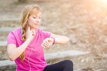 Image showing Young Fit Adult Woman Outdoors in Workout Clothes Listening To M