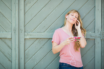 Image showing Outdoor Portrait of Young Adult Brown Eyed Woman Listening To Mu