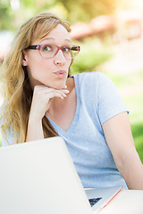 Image showing Young Adult Woman Wearing Glasses Outdoors Using Her Laptop.