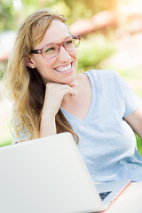 Image showing Young Adult Woman Wearing Glasses Outdoors Using Her Laptop.