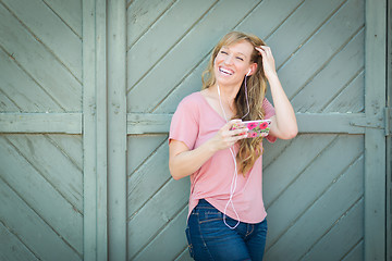 Image showing Outdoor Portrait of Young Adult Brown Eyed Woman Listening To Mu