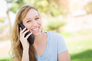 Image showing Young Adult Woman Outdoors Talking on Her Smart Phone.