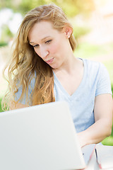 Image showing Young Adult Woman Live Video Chatting Outdoors Using Her Laptop.