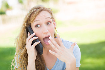 Image showing Stunned Young Woman Outdoors Talking on Her Smart Phone.