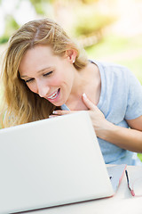 Image showing Young Adult Woman Live Video Chatting Outdoors Using Her Laptop.