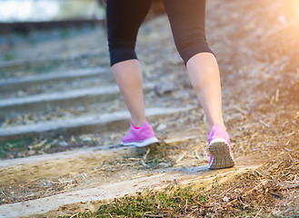 Image showing Young Fit Adult Woman Outdoors Walking or Running Up Wooden Step