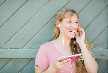 Image showing Outdoor Portrait of Young Adult Brown Eyed Woman Listening To Mu