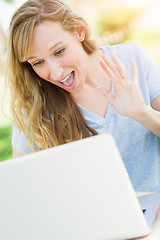 Image showing Young Adult Woman Live Video Chatting Outdoors Using Her Laptop.