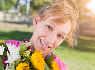 Image showing Outdoor Portrait of an Excited Young Adult Brown Eyed Woman Hold