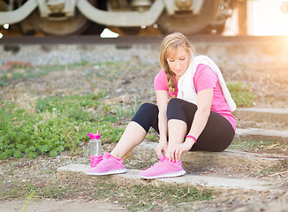 Image showing Young Adult Woman Outdoors With Towel and Water Bottle Tying Her