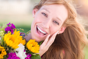 Image showing Outdoor Portrait of an Excited Young Adult Brown Eyed Woman Hold