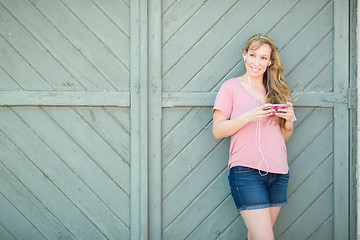 Image showing Outdoor Portrait of Young Adult Brown Eyed Woman Listening To Mu