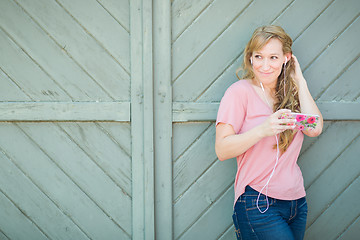 Image showing Outdoor Portrait of Young Adult Brown Eyed Woman Listening To Mu