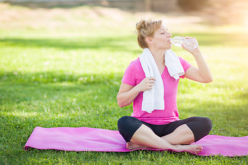 Image showing Young Fit Adult Woman Outdoors On Her Yoga Mat with Towel Drinki