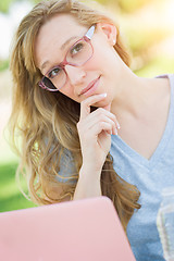 Image showing Young Adult Woman Wearing Glasses Outdoors Using Her Laptop.