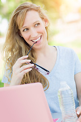 Image showing Young Adult Woman With Glasses Outdoors Using Her Laptop.