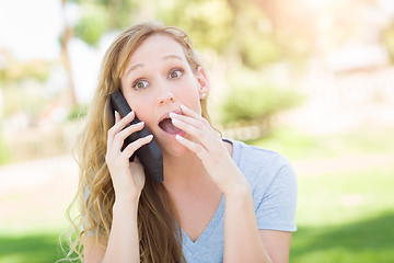 Image showing Stunned Young Woman Outdoors Talking on Her Smart Phone.
