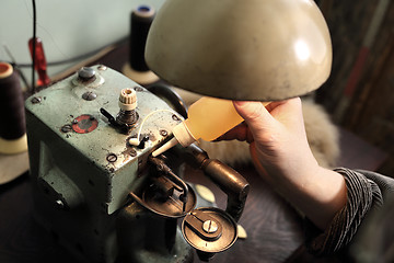 Image showing Tailor lubricates the sewing machine lubricant 