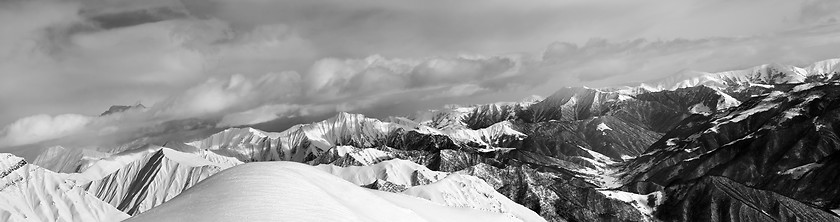 Image showing Black and white panorama of off-piste snowy slope and cloudy mou