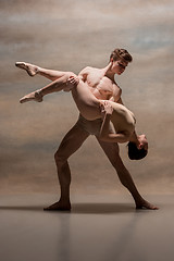 Image showing Couple of ballet dancers posing over gray background