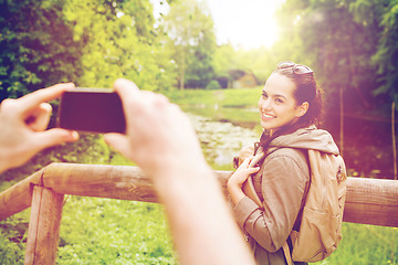 Image showing couple with backpacks taking picture by smartphone