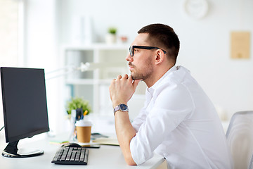 Image showing businessman in glasses sitting at office computer