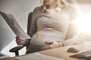 Image showing pregnant businesswoman reading papers at office