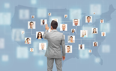 Image showing businessman touching virtual screen with contacts