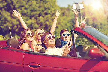 Image showing friends driving in cabriolet car and taking selfie