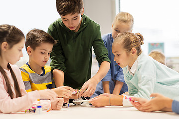 Image showing happy children building robots at robotics school