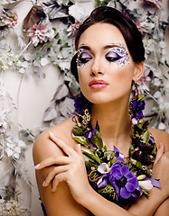 Image showing floral face art with anemone in jewelry, sensual young brunette woman in studio close up