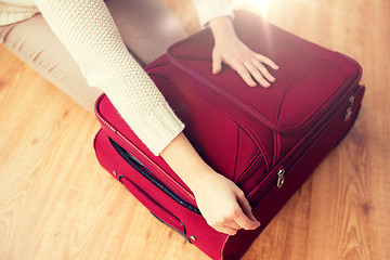 Image showing close up of woman packing travel bag for vacation