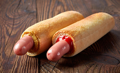 Image showing two hotdogs on wooden table